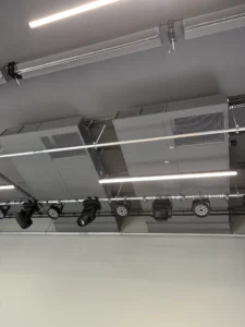 Commercial HVAC ventilation system installed above track lighting in a modern interior