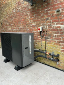 Samsung air source heat pump installed outdoors on raised brackets beside a timber fence in Liverpool